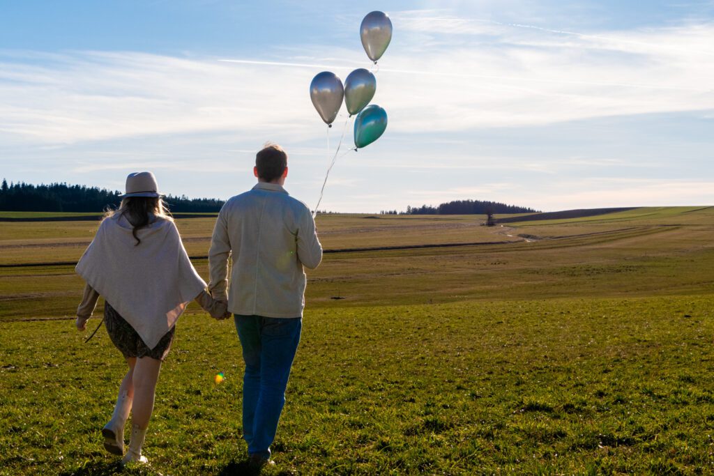 Paarfoto mit Luftballons auf Wiese