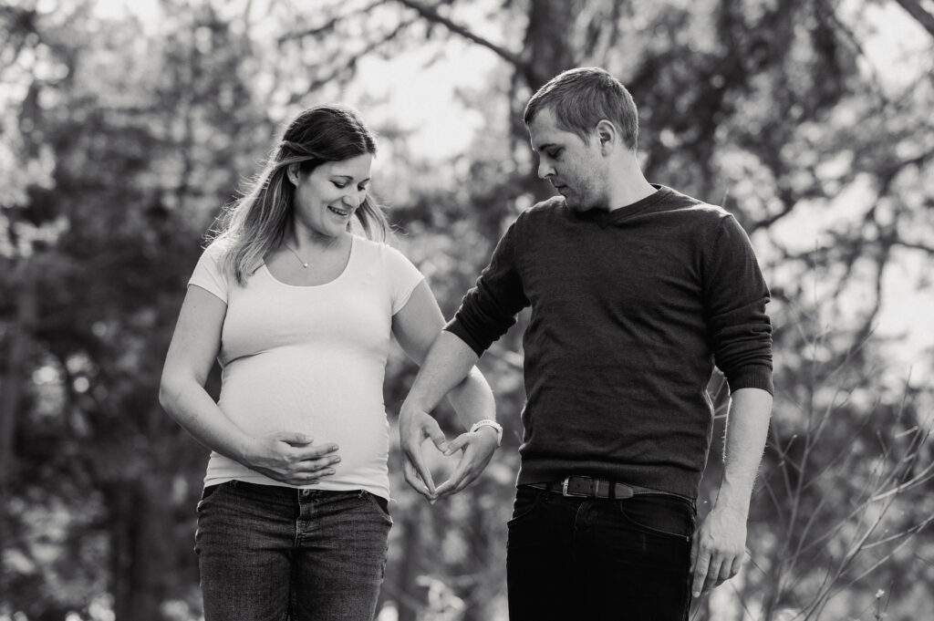 Babybauchshooting_Ybbs_an_der_Donau_Carografie_Caroline_Nagl-3661 Paar formt Herz mit Händen im Wald