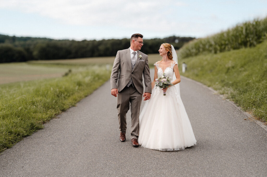 Hochzeitspaar spaziert Straße entlang