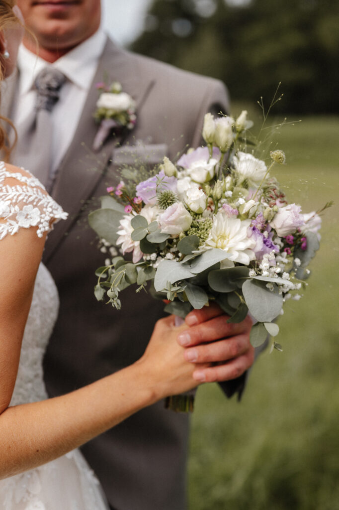 Brautstrauß in den Händen des Brautpaares