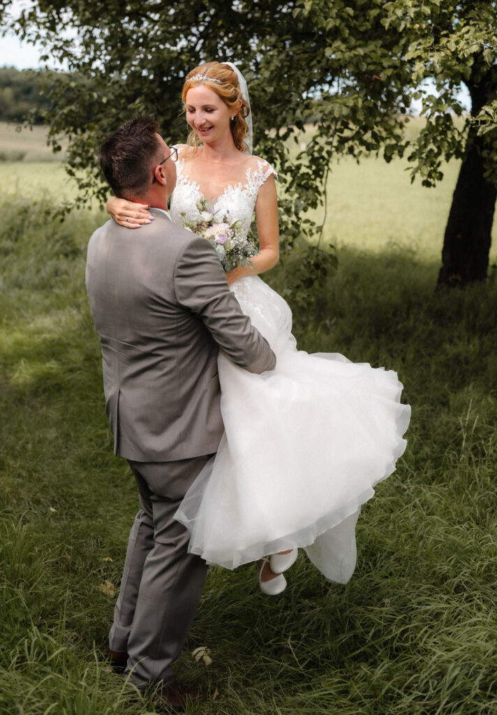 Bräutigam trägt seine Braut auf Händen