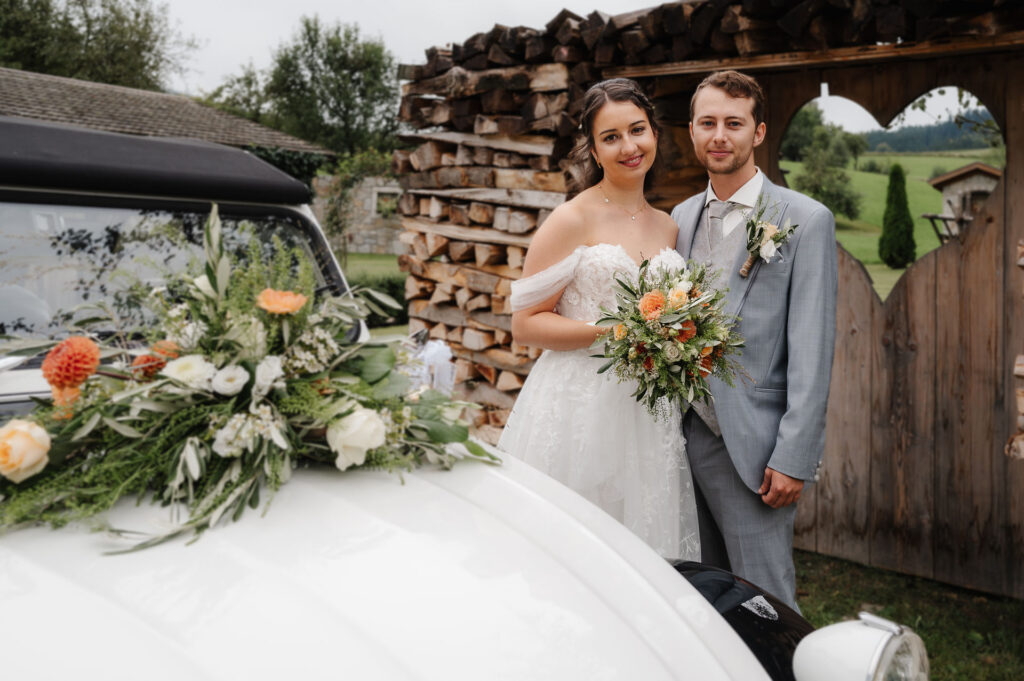 Brautpaar neben Oldtimer stehend beim Gasthaus Pammer in OÖ