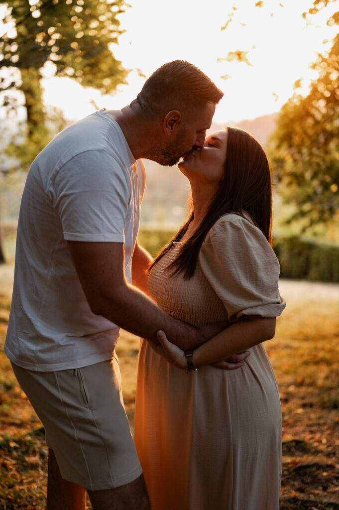 Babybauchshooting_Linz_Caroline_Nagl_Carografie-0071 Kuss im Sonnenuntergang