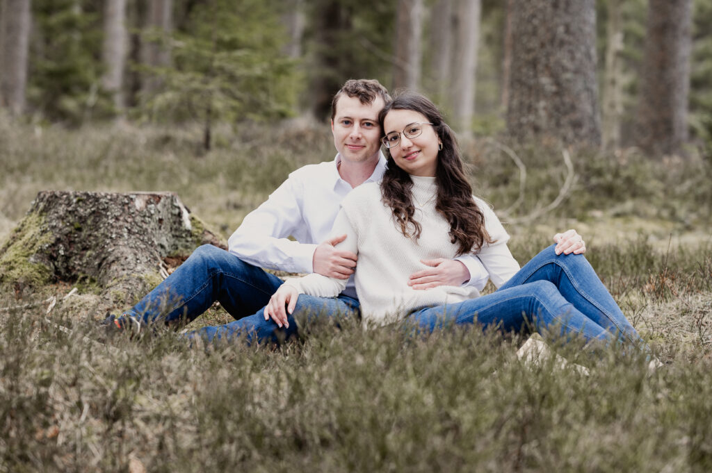 Paar im Wald sitzend bei Fotoshooting