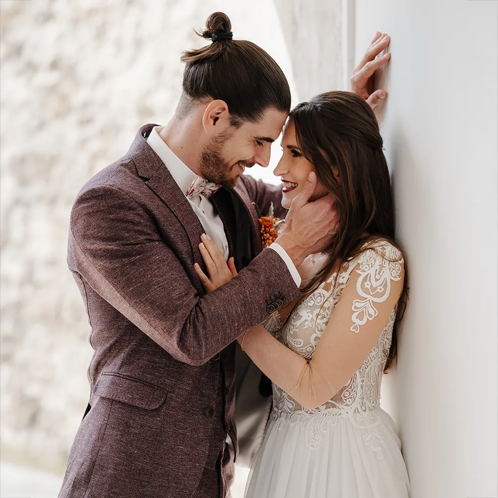 Brautpaar lächelt sich am Hochzeitstag liebevoll an