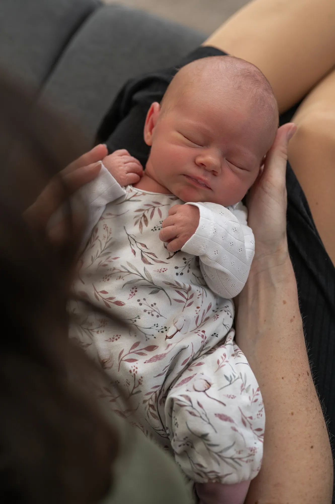 Eltern betrachten ihr Baby liebevoll beim natürlichen Newbornshooting